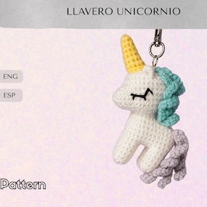 Puede incluir: Un llavero de unicornio tejido a mano. El unicornio es blanco con un cuerno amarillo, melena azul y cola lavanda. El llavero tiene un anillo de metal plateado en la parte superior. El texto "LLAVERO UNICORNIO" está en la parte superior.