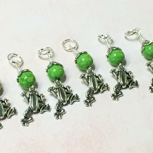 Puede incluir: Seis marcadores de punto de rana verdes y plateados. Cada marcador presenta una cuenta verde con un amuleto de rana plateado.