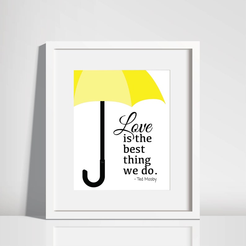 May include: A white framed print with a yellow umbrella and a quote that reads "Love is the best thing we do. - Ted Mosby"
