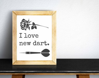 May include: A framed print with a black and white illustration of a rose and a dart. The text reads "I love new dart."