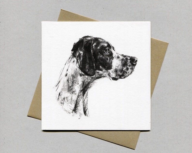K&ouml;nnte beinhalten: Quadratische Karte mit einer Kohlezeichnung des Profils eines Hundes. Der Hund hat ein schwarz-wei&szlig;es Fell und blickt zur Seite. Die Karte liegt auf einem braunen Umschlag und erzeugt eine schlichte, elegante Pr&auml;sentation.