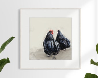 Op de afbeelding: Een ingelijste kunstdruk met twee zwarte kippen met rode kammen. Het schilderij maakt gebruik van losse penseelstreken op een neutrale achtergrond. Het kunstwerk wordt gepresenteerd in een witte lijst, ideaal voor rustieke decoratie.
