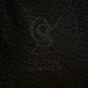 May include: Dark, textured fabric with a subtle leopard print pattern. The image features the text "OH SEW SUMMER" in a stylized font, along with a logo. The overall aesthetic is dark and moody.