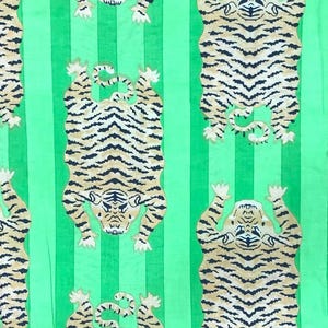 May include: Green fabric with vertical stripes and a repeating pattern of tigers. The tigers are depicted in a stylized, cartoonish manner, with black stripes on a tan background. The tigers are in various poses.