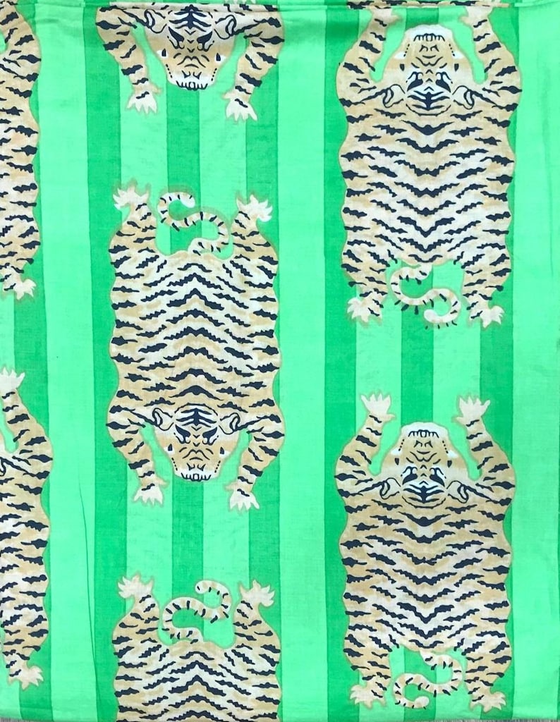 May include: Green fabric with vertical stripes and a repeating pattern of tigers. The tigers are depicted in a stylized, cartoonish manner, with black stripes on a tan background. The tigers are in various poses.