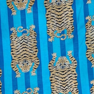 May include: Fabric with a repeating pattern of stylized tigers in tan and black stripes against a background of vertical blue stripes. The tigers are depicted in a playful, upright pose.