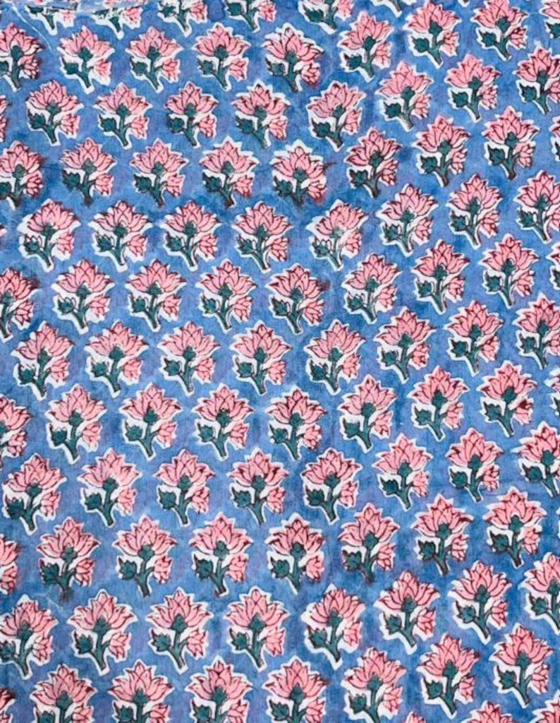 以下が含まれることがあります： 繰り返し模様の生地のクローズアップ。花はピンク色で緑の葉があり、青色の背景に配置されています。デザインは均等に配置され、視覚的に魅力的なテキスタイルを作成しています。