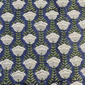May include: A repeating pattern of white floral shapes with green leaves on a dark blue background. The floral design is evenly spaced, creating a symmetrical and visually appealing textile pattern. The fabric has a textured appearance.