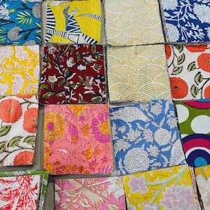 May include: A collection of colorful fabric squares with various floral and geometric patterns. The squares feature a range of colors, including blue, yellow, pink, and red, with detailed designs of flowers, leaves, and abstract shapes. The fabric appears to be cotton or a similar material.