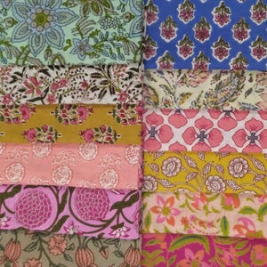 May include: A collection of colorful fabric swatches with floral patterns. The fabrics feature a variety of designs, including large and small flowers, leaves, and paisley motifs. Colors include blue, pink, yellow, and green.