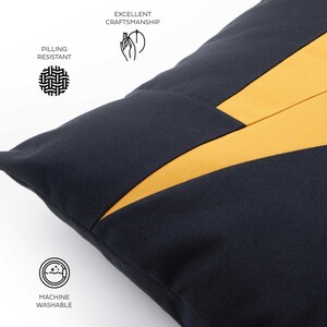 Puede incluir: Una almohada azul marino con un dise&ntilde;o geom&eacute;trico amarillo. La almohada es lavable a m&aacute;quina y presenta una excelente calidad de elaboraci&oacute;n.