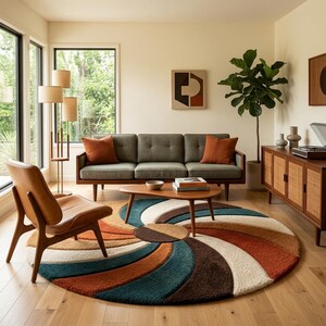 May include: A large circular area rug featuring a vibrant, swirling radial pattern in shades of deep teal, burnt orange, cream, and dark brown. The rug has a thick, textured pile and is positioned on a light-coloured wooden floor in a room.