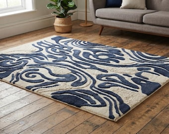 May include: A rectangular area rug featuring a high-low pile texture with a bold, abstract pattern in deep navy blue against a cream-colored background. The design consists of fluid, organic, and swirling shapes that create a raised, tactile surface.