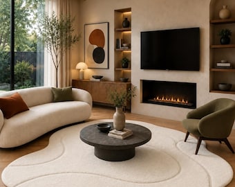 May include: A large, cream-colored, organic-shaped area rug with subtle, flowing, recessed wave patterns. The rug features a soft, textured pile and is positioned on a light-toned wooden floor, serving as a central foundation for the living room furniture.