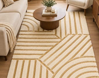 May include: A rectangular area rug featuring a high-low pile texture with a geometric pattern of cream-colored arcs and straight lines set against a mustard yellow background, creating a raised, tactile surface design across the entire floor covering.