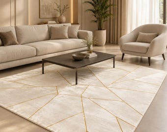 May include: A rectangular area rug featuring a cream-colored surface with a geometric pattern of thin, intersecting gold lines. The rug is positioned on a floor in front of a sofa and coffee table, showcasing a low-pile texture and clean edges.