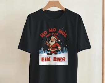 Könnte beinhalten: Schwarzes T-Shirt mit einem Cartoon-Weihnachtsmann, der ein Bier hält, mit dem Text "HO HO HOL MIR MAL EIN BIER". Der Weihnachtsmann trägt einen roten Anzug und einen weißen Bart. Das Design beinhaltet Schnee und Bäume.