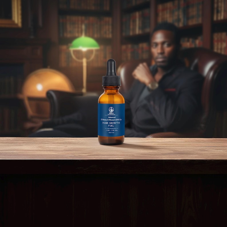 May include: A brown glass bottle with a black dropper, labeled "Advanced Hair Growth Fuel." The bottle has a blue label with white text and a logo. The bottle is on a wooden surface, with a blurred background of a library and a person.