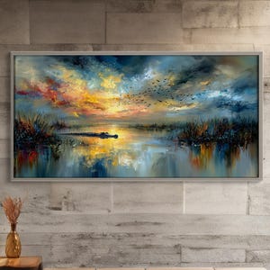 May include: A framed landscape painting depicts a swamp scene with a sunset. The artwork features a vibrant sky with orange, yellow, and blue hues, reflecting in the water. Silhouettes of birds fly across the sky.