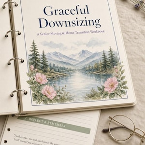 May include: A ring-bound workbook titled Graceful Downsizing: A Senior Moving & Home Transition Workbook. The cover features a watercolor landscape of mountains, a lake, and pine trees with pink flowers. Below, a page shows Psalm 32:8 text.