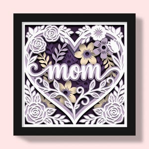 May include: A layered paper art piece in a black frame, featuring a heart-shaped design with the word "mom" in the center. The heart is surrounded by white floral cutouts and filled with purple and cream-colored flowers.
