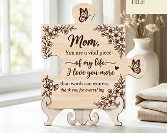 Puede incluir: Una pieza de rompecabezas de madera con las palabras "Mamá, Eres una pieza vital de mi vida, te amo más de lo que las palabras pueden expresar, gracias por todo". El rompecabezas tiene diseños florales y de mariposas. También se ven las palabras "LASER CUT FILE" y "DESCARGA DIGITAL".