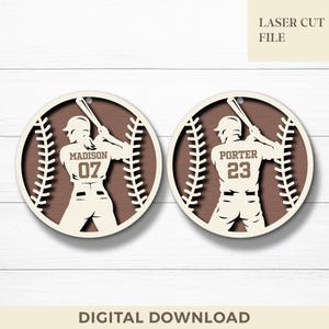 May include: Two baseball-themed laser-cut files. Each circular design features a baseball player silhouette with a bat, set within a baseball shape. One reads "Madison 07", the other "Porter 23". The text "Laser Cut File" and "Digital Download" are also present.