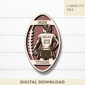 Può includere: Un ornamento in legno a forma di pallone da football con un design tagliato al laser. Raffigura un giocatore di football con il nome "Riley" e il numero "23" sulla maglia. Sono inclusi anche l'anno "2025" e la parola "Titans". Sono presenti anche i testi "LASER CUT FILE" e "DIGITAL DOWNLOAD".