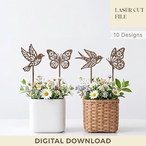 May include: Two floral arrangements with decorative metal bird and butterfly toppers. One arrangement is in a white square pot, the other in a woven basket. The image includes the text "LASER CUT FILE" and "10 Designs" and "DIGITAL DOWNLOAD".