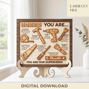 May include: A wooden sign featuring the text DADDY YOU ARE and YOU ARE OUR SUPERHERO, with laser-cut illustrations of a tape measure, hammer, drill, wrench, saw, screwdriver, flashlight, and level, each paired with descriptive text about the tool.