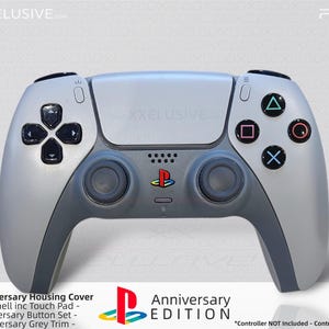 Peut inclure: Une manette PS5 grise et gris foncé, édition anniversaire. La manette a des boutons noirs et un logo PlayStation coloré. Le texte "30th Anniversary Housing Cover" et "Anniversary Edition" sont visibles.