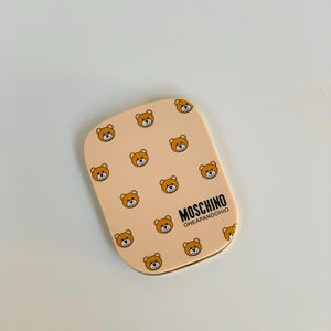 Espejo vintage de osito de peluche Moschino con peine incorporado: un espejo de bolsillo excepcional de los años 90.