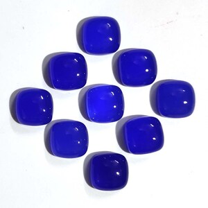 Puede incluir: Nueve gemas cuadradas pulidas, de color azul vibrante, dispuestas sobre una superficie blanca. Cada gema tiene esquinas redondeadas y un acabado brillante, que refleja la luz. Las gemas est&aacute;n espaciadas uniformemente, creando un patr&oacute;n visualmente atractivo. Ideal para joyer&iacute;a o artesan&iacute;a.