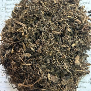 May include: A close-up of a pile of brown mulch, composed of shredded wood, bark, and plant fibers. The texture is rough and fibrous, with varying shades of brown and tan. The mulch appears to be freshly prepared.
