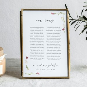 Op de afbeelding: Een verticale rechthoekige messing lijst met een gedrukt document getiteld our vows, voorzien van twee tekstkolommen, bloemillustraties in de hoeken, de namen mr and mrs johnston en de datum may 04 2024 en siena, italy.