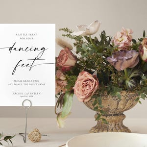 minimalist wedding sign in natural wood frame with blush and peach floral arrangement, elegant wedding table decor, printable wedding signage template, romantic reception styling, soft neutral wedding aesthetic