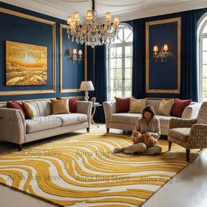 Könnte beinhalten: Ein Wohnzimmer mit einem großen gelb-weiß gemusterten Teppich. Zwei beigefarbene Sofas mit Zierkissen stehen vor einer dunkelblauen Wand. Ein Kronleuchter hängt von der Decke, und eine Person sitzt auf dem Teppich.