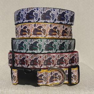 Puede incluir: Una pila de collares para perros con un patrón repetido de sombreros de mago, botellas de pociones y otros objetos mágicos. Los collares son de varios colores, incluyendo azul, amarillo, verde y rojo, con hebillas de plástico negro y anillas en D de metal.