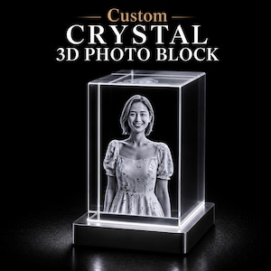May include: A custom crystal 3D photo block with a woman's image inside. The clear, rectangular block sits on a silver base, and the text "Custom CRYSTAL 3D PHOTO BLOCK" is at the top.