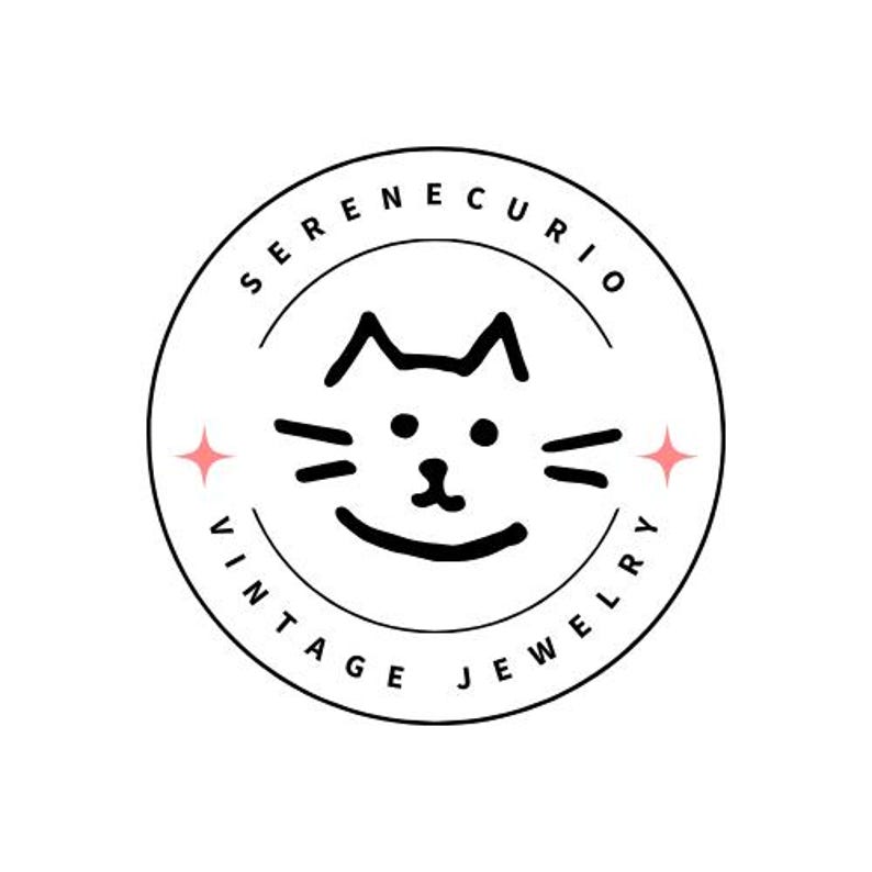 Może przedstawiać: Okrągłe logo z napisem "SERENECURIO VINTAGE JEWELRY" otaczającym twarz kota z kresk&oacute;wki. Twarz kota jest czarna z wąsami i uśmiechniętymi ustami. R&oacute;żowe rozbłyski gwiazd flankują twarz kota.