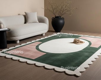 Alfombra ovalada festoneada hecha a mano, con diseño abstracto en tonos verdes y rosados.