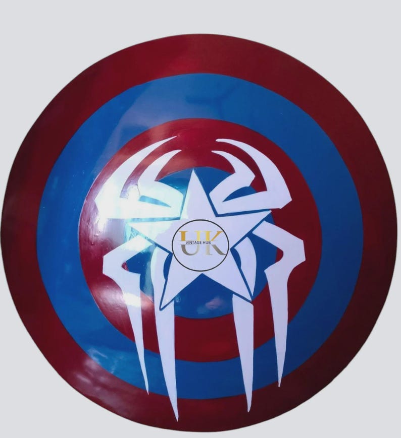 May include: A circular shield in red, white, and blue. The design features a white star at the centre, with a spider-like pattern and the text "VINTAGE HUB" in a circle. This shield is likely a decorative item or a collectible.