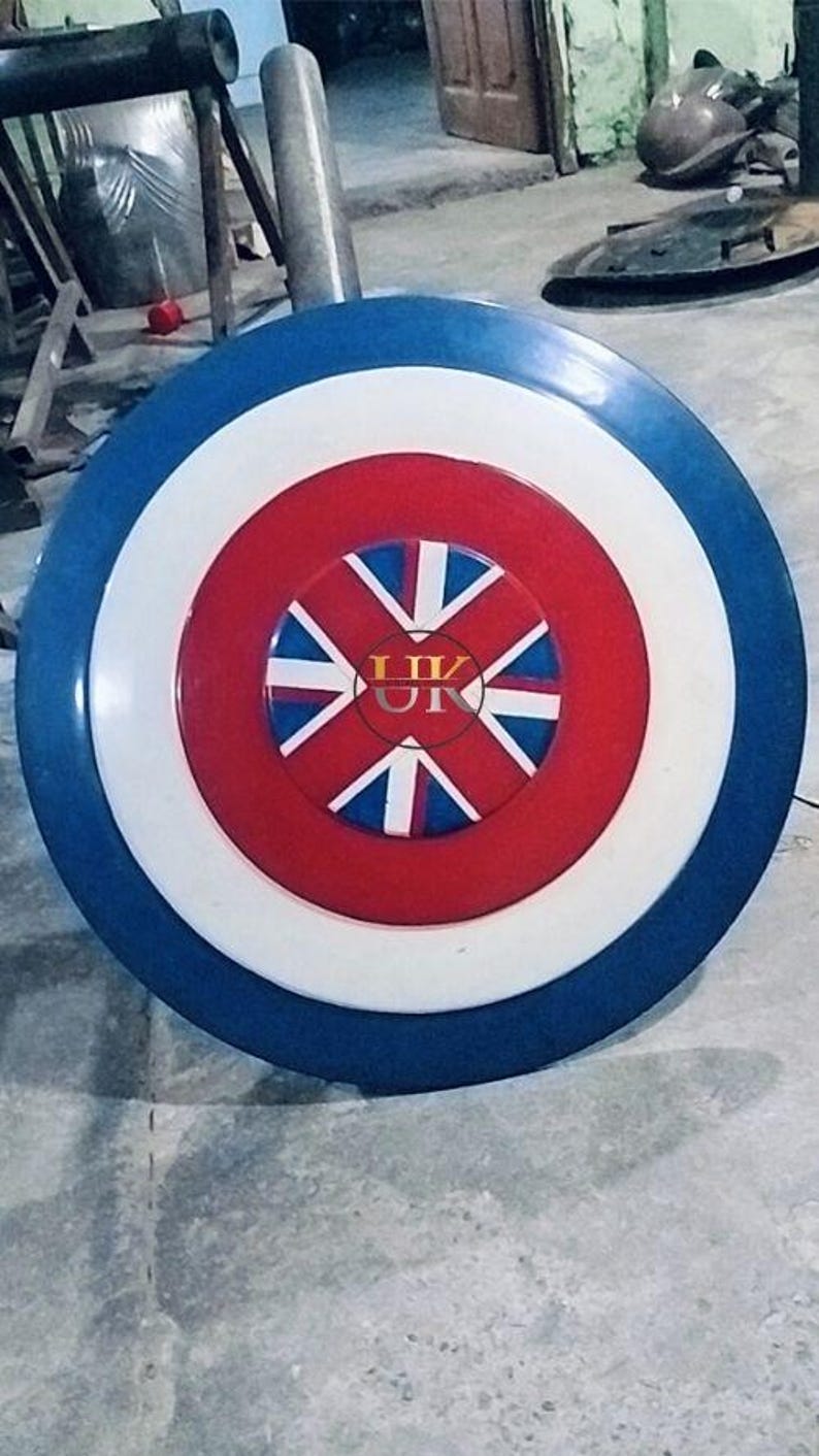 May include: A round shield with a blue outer ring, a white middle ring, and a red center. The center features a design with white and blue elements, and the letters "UK" are visible.