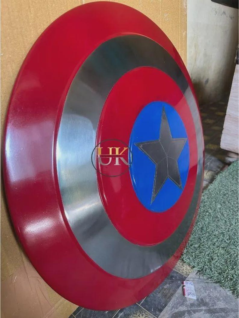 K&ouml;nnte beinhalten: Ein kreisf&ouml;rmiger Schild mit einem gl&auml;nzenden roten Au&szlig;enring, einem metallisch silbernen Mittelring und einem leuchtend blauen Mittelkreis. Ein dunkelgrauer f&uuml;nfzackiger Stern befindet sich in der Mitte des blauen Kreises. Die Buchstaben UK sind sichtbar.