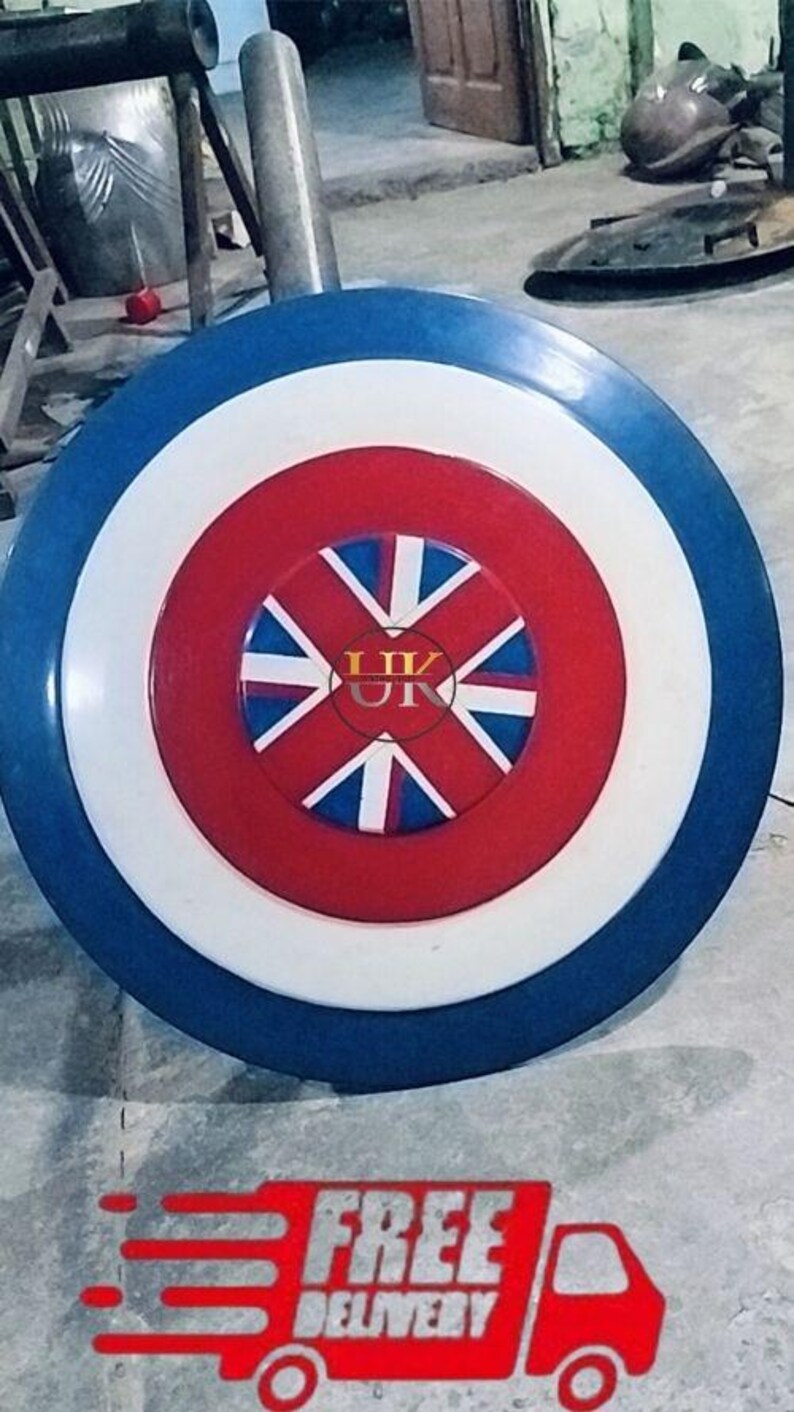May include: A round shield with a blue, white, and red color scheme. The shield features a central red circle with a Union Jack design. The outer ring is blue, and the middle ring is white. The shield has a UK logo in the center.