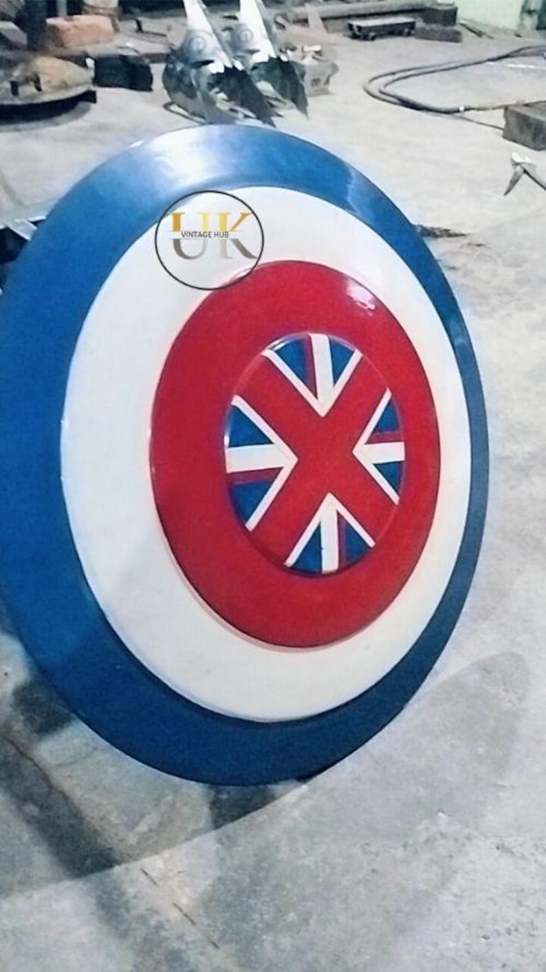 May include: A round shield with a blue, white, and red color scheme. The shield features a central red emblem with a white and blue cross design. The outer edge is blue, with a white and red ring in the center. The logo "UK VINTAGE HUB" is in the center.