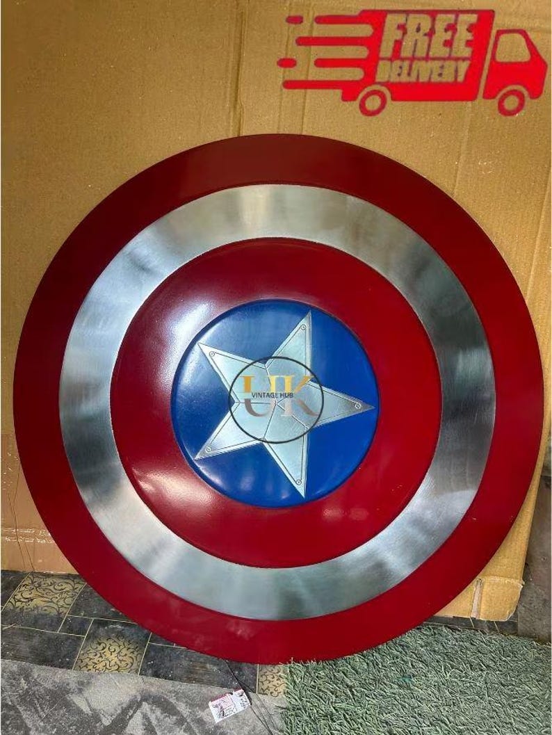 K&ouml;nnte beinhalten: Ein kreisf&ouml;rmiger Schild mit konzentrischem Design, bestehend aus einem dunkelroten Au&szlig;enring, einem metallisch silbernen Mittelring und einem blauen Innenkreis mit einem gro&szlig;en silbernen f&uuml;nfzackigen Stern. Der Text VINTAGE HUB ist aufgedruckt.