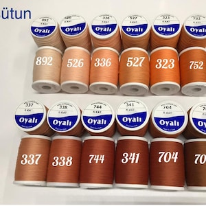 May include: A collection of spools of thread in various shades of orange, brown, and beige. Each spool is labeled with a number and the brand name "Oyalı". The image includes the text "6. sütun".