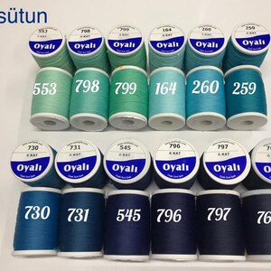 May include: A collection of spools of thread in various shades of blue and green. Each spool is labeled with a number and the brand name "Oyalı". The text "16.sütun" is at the top left.