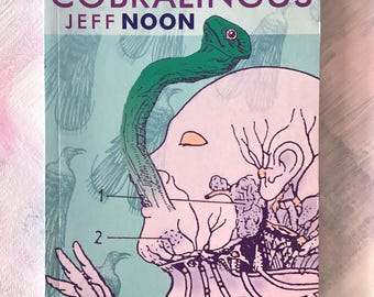 May include: A book cover for "Cobralingus" by Jeff Noon. The cover features a surreal illustration of a green snake emerging from a human head, with anatomical details and the text "INTRODUCED BY MICHAEL BRACEWELL".